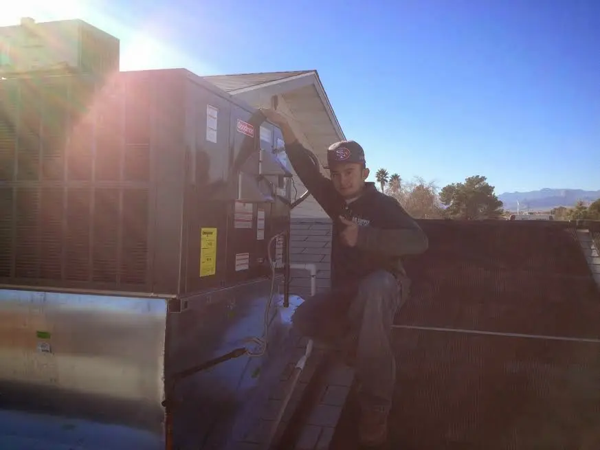 HVAC technician performing AC Tune-Up on a rooftop unit in Haltom City
